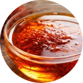 Red saffron threads in a small wooden bowl